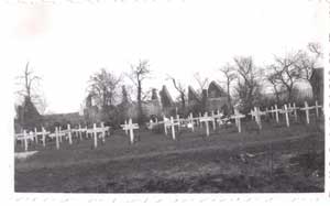 Photo du cimetière provisoire de Villy-la-Ferté. Les ruines du village sont visibles derrière.